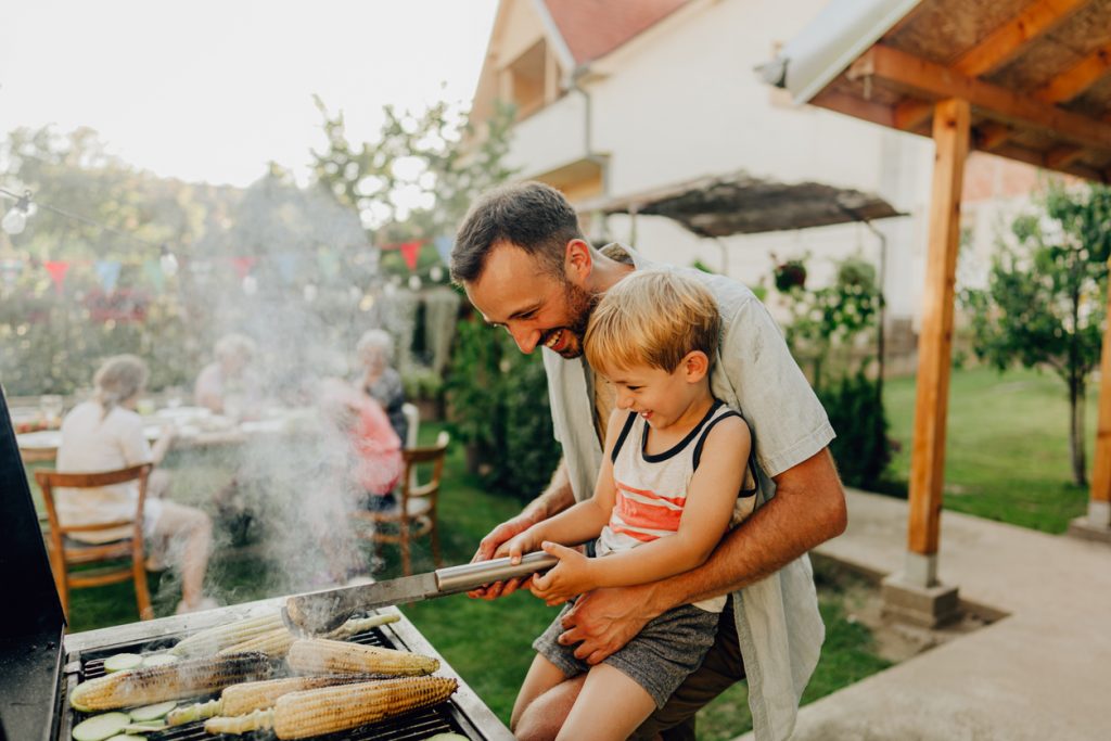 father and son cooking on barbecue