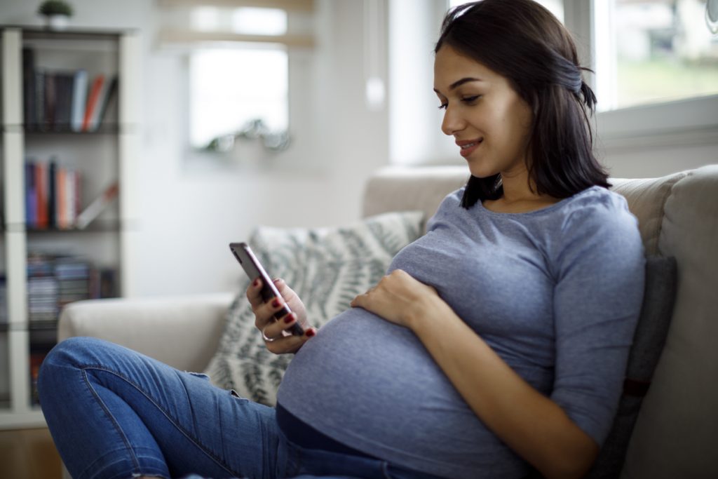 pregnant woman looking at her phone